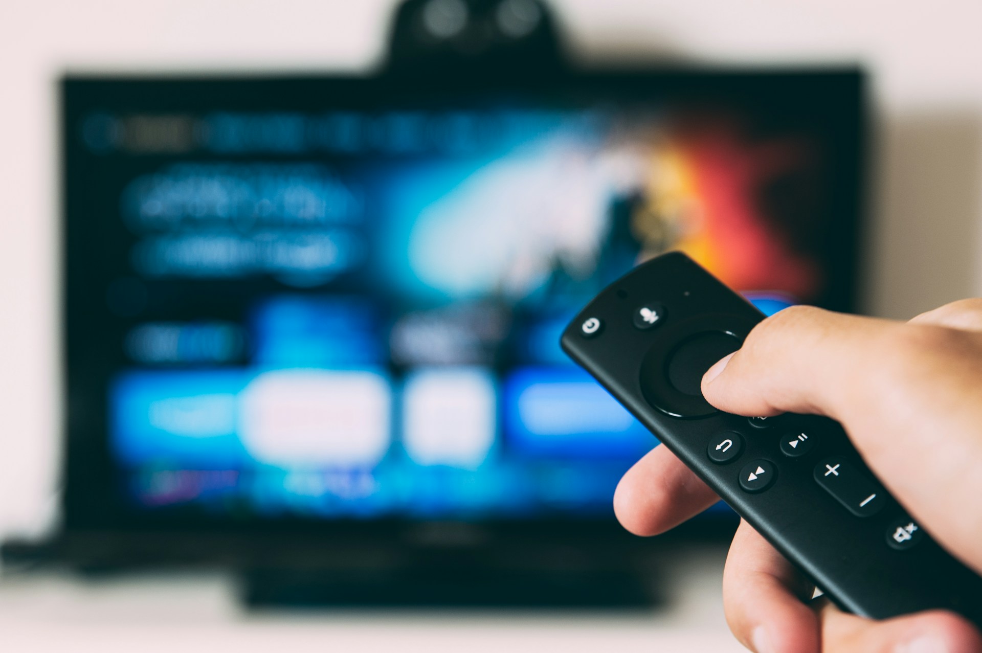 A Firestick remote in front of a television