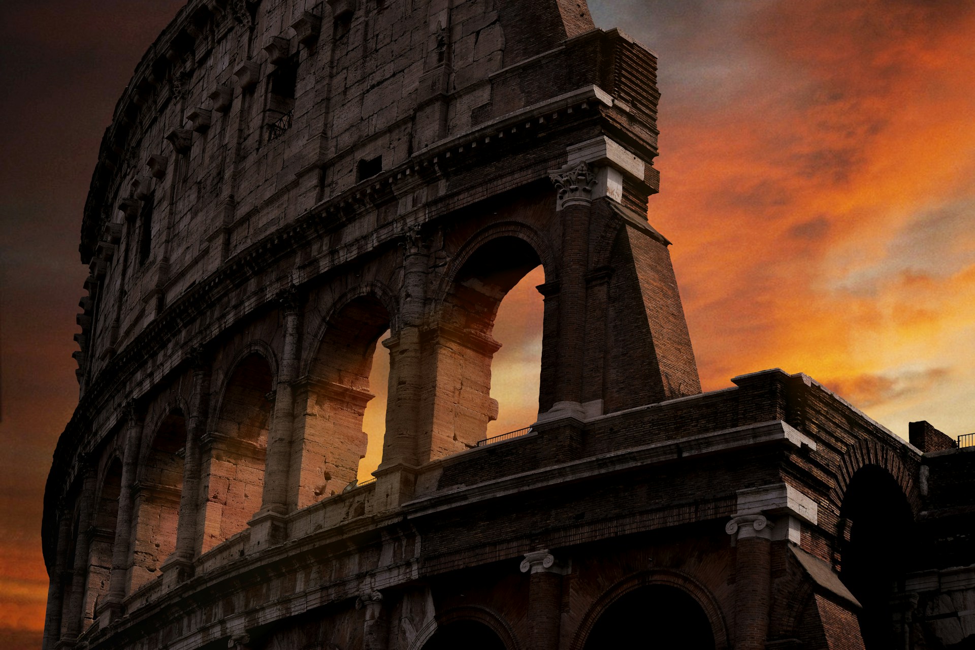 rounded concrete building with arches under a red sky